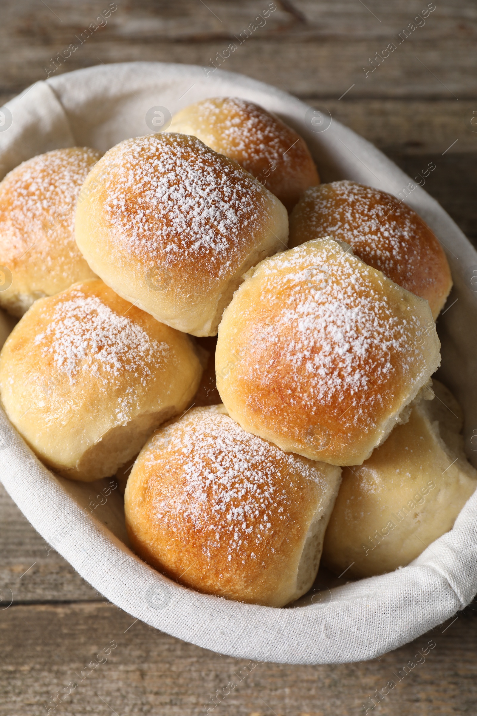 Photo of Delicious dough balls in basket on wooden table, top view