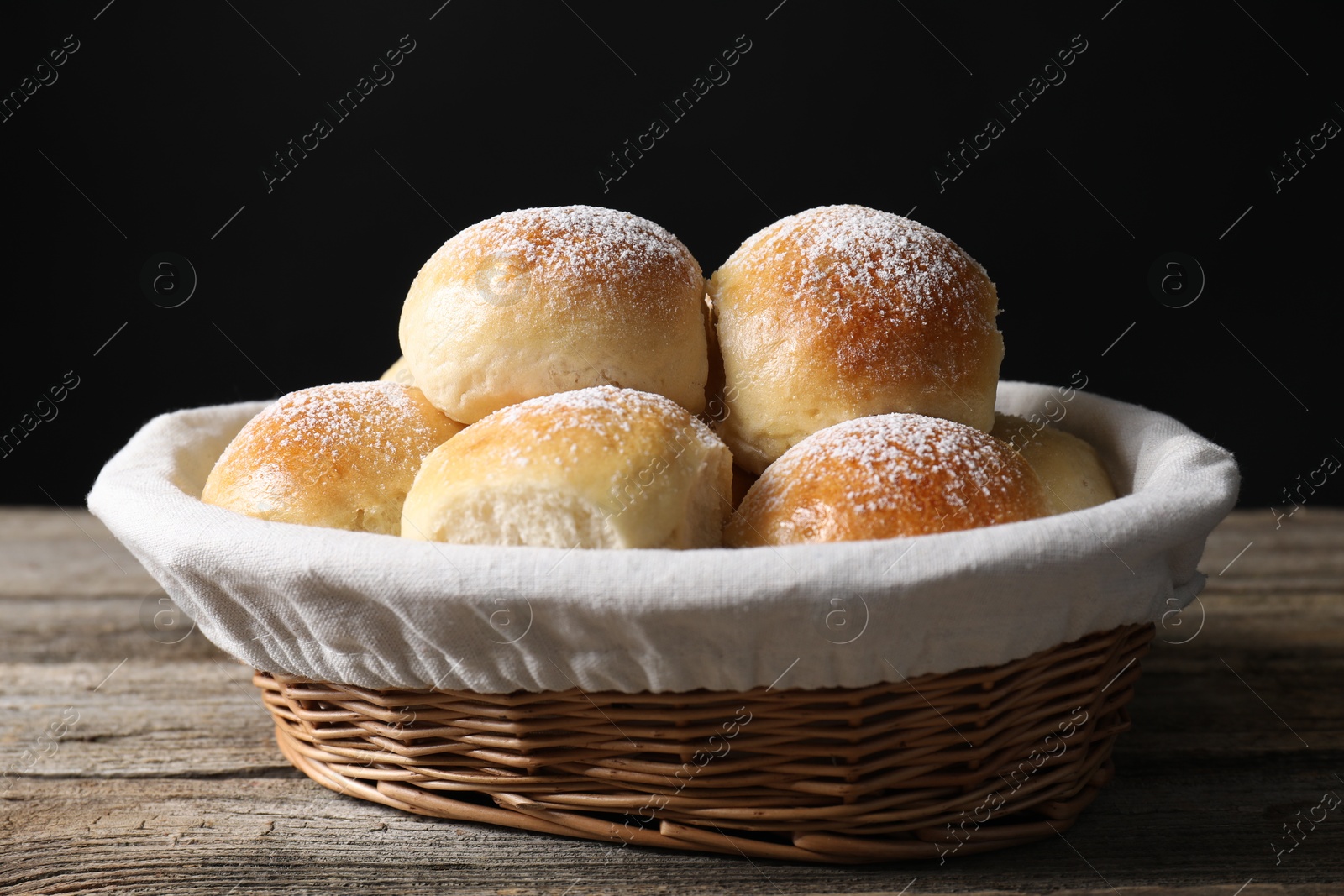 Photo of Delicious dough balls in basket on wooden table