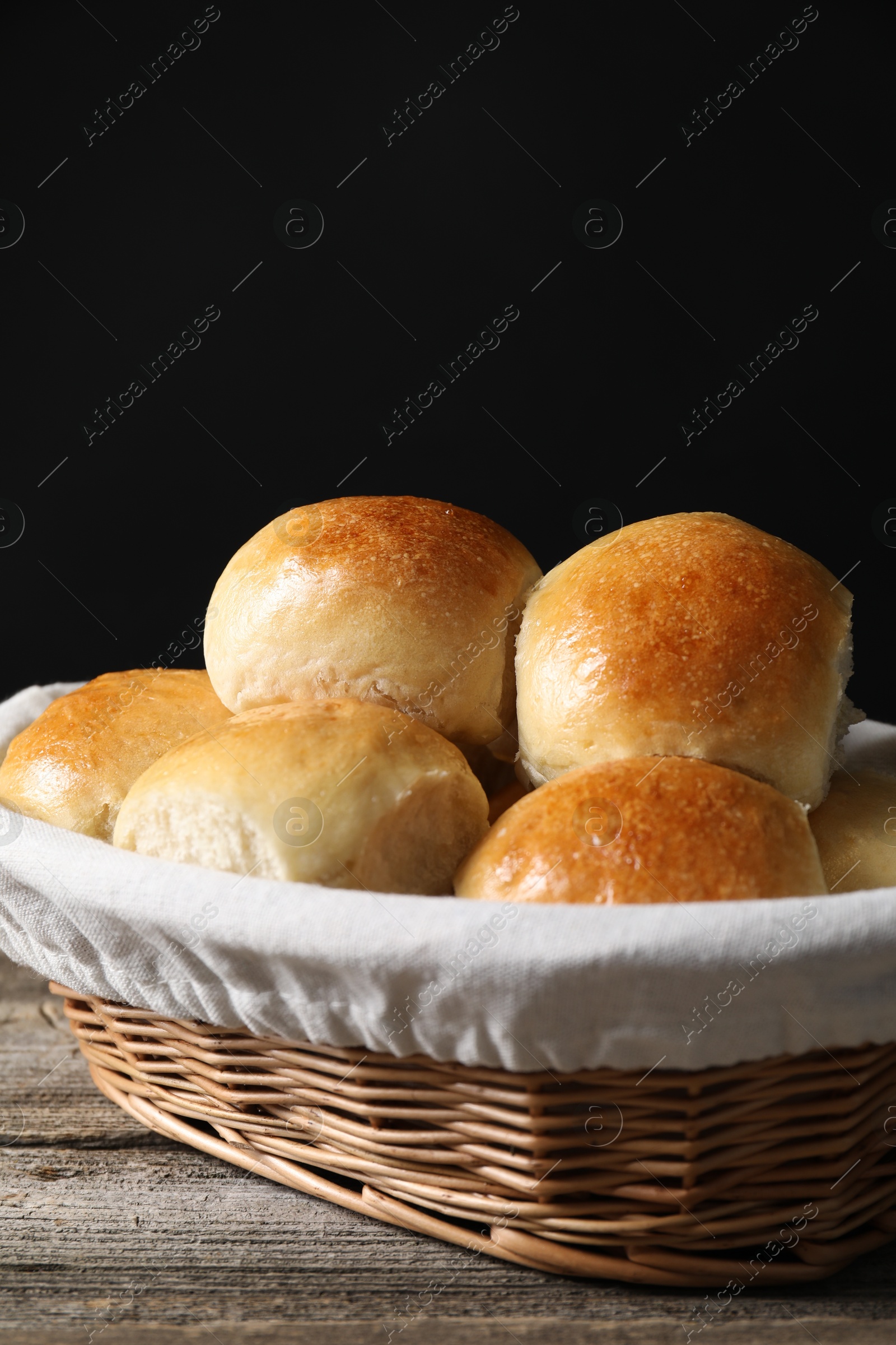 Photo of Delicious dough balls in basket on wooden table