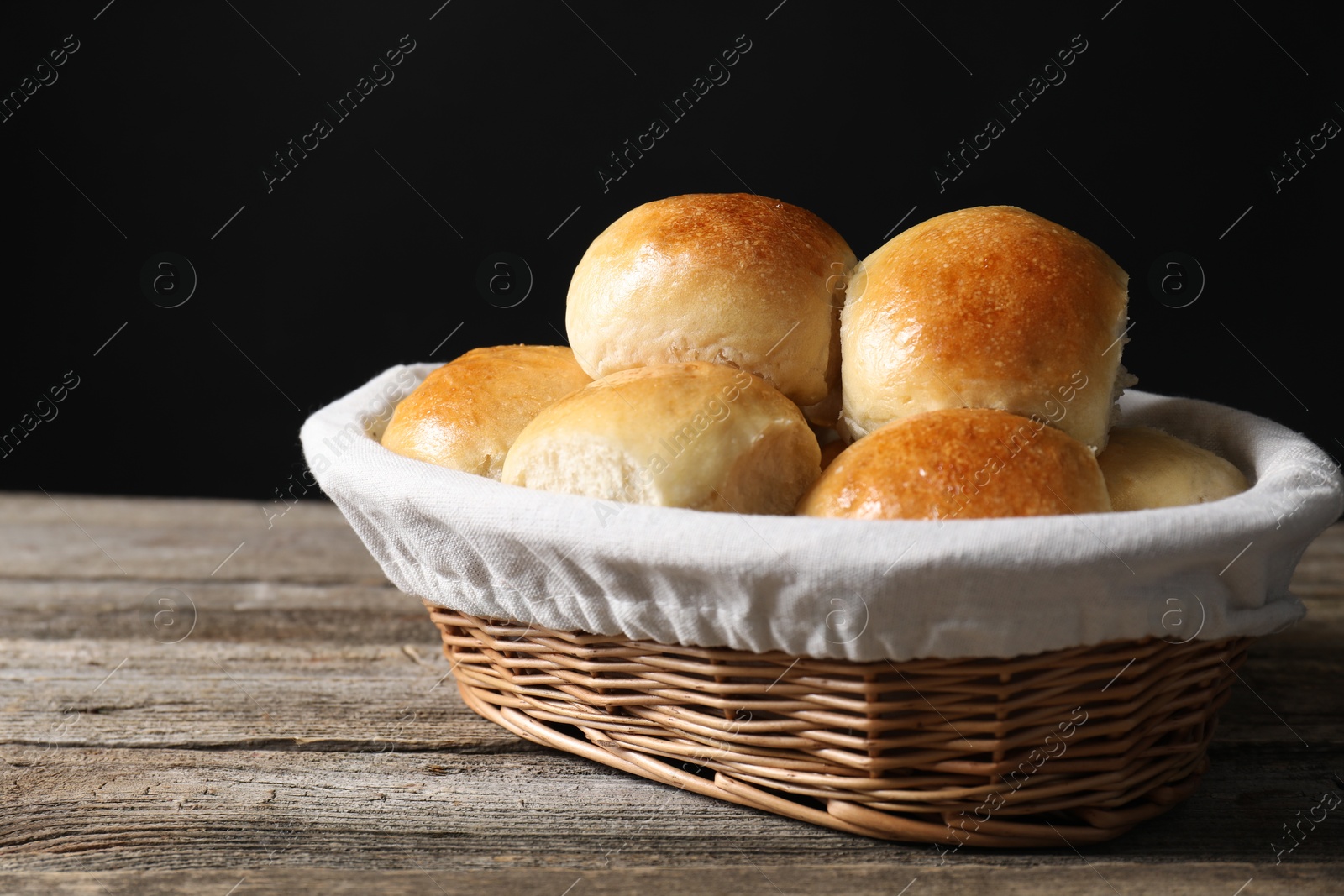 Photo of Delicious dough balls in basket on wooden table