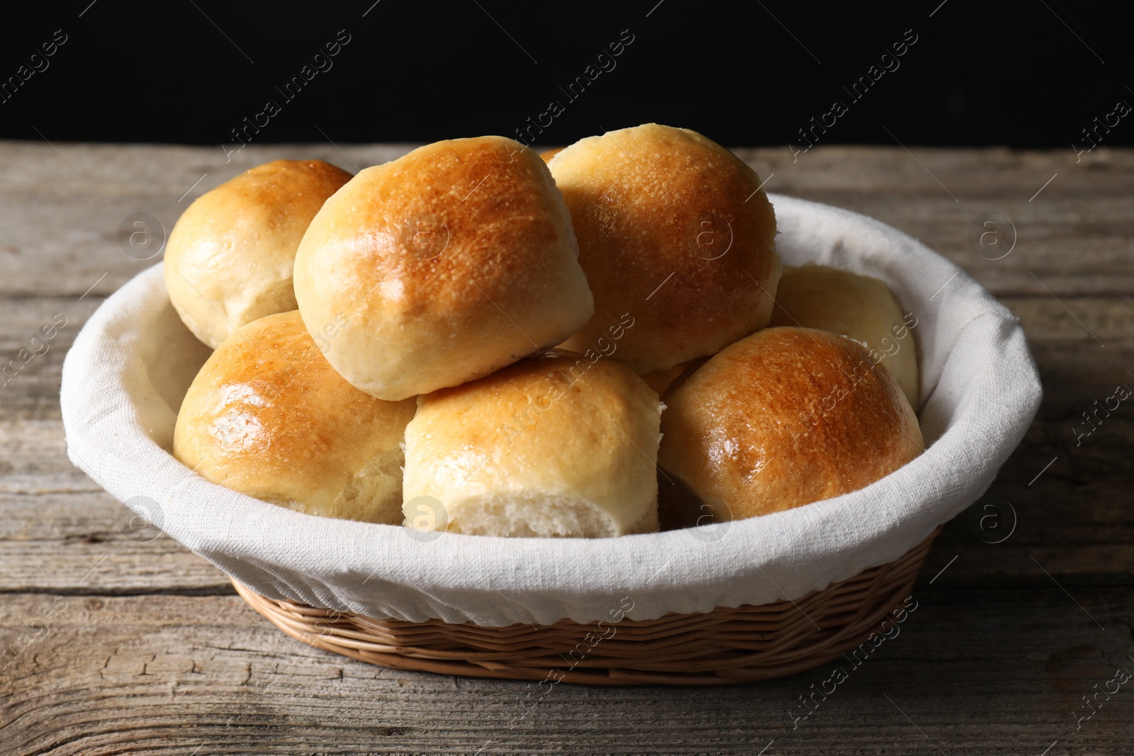 Photo of Delicious dough balls in basket on wooden table