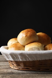 Photo of Delicious dough balls in basket on wooden table