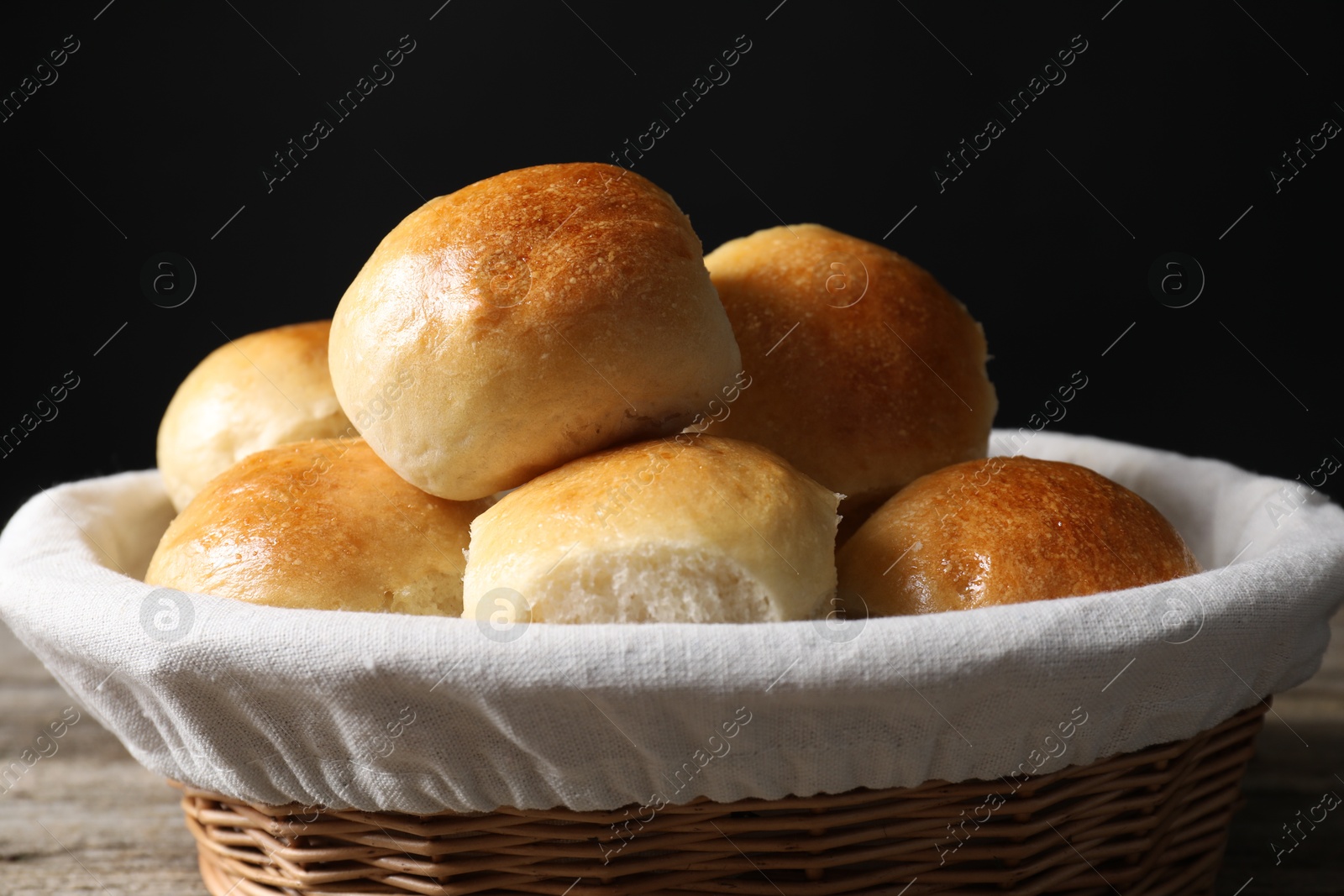 Photo of Delicious dough balls in basket on table, closeup