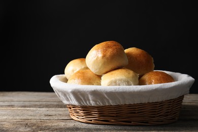 Photo of Delicious dough balls in basket on wooden table