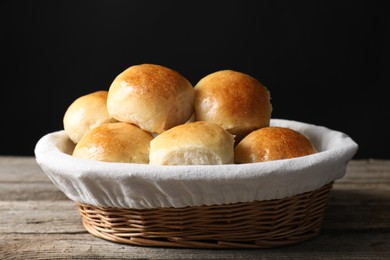 Photo of Delicious dough balls in basket on wooden table