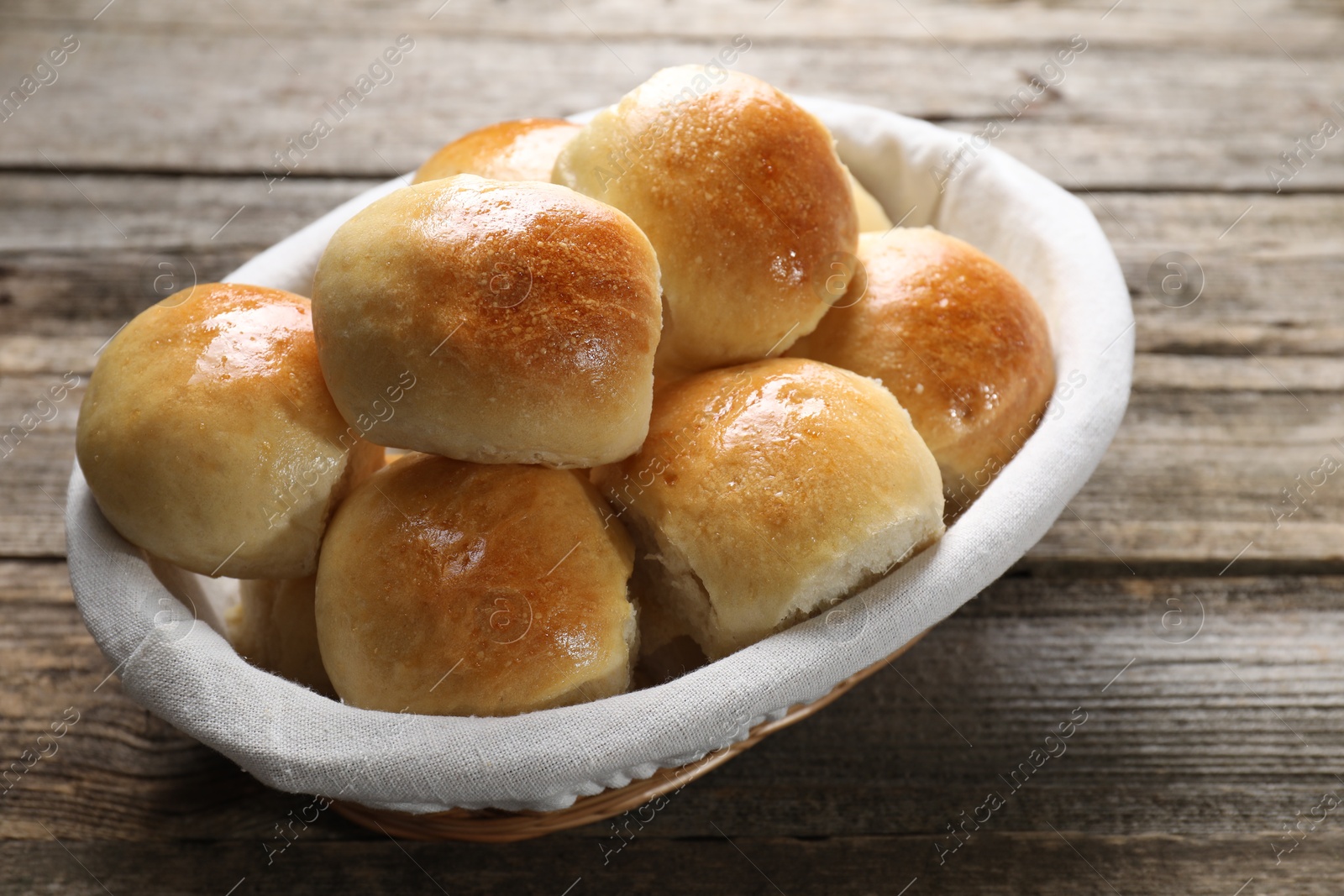 Photo of Delicious dough balls in basket on wooden table