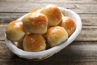 Delicious dough balls in basket on wooden table