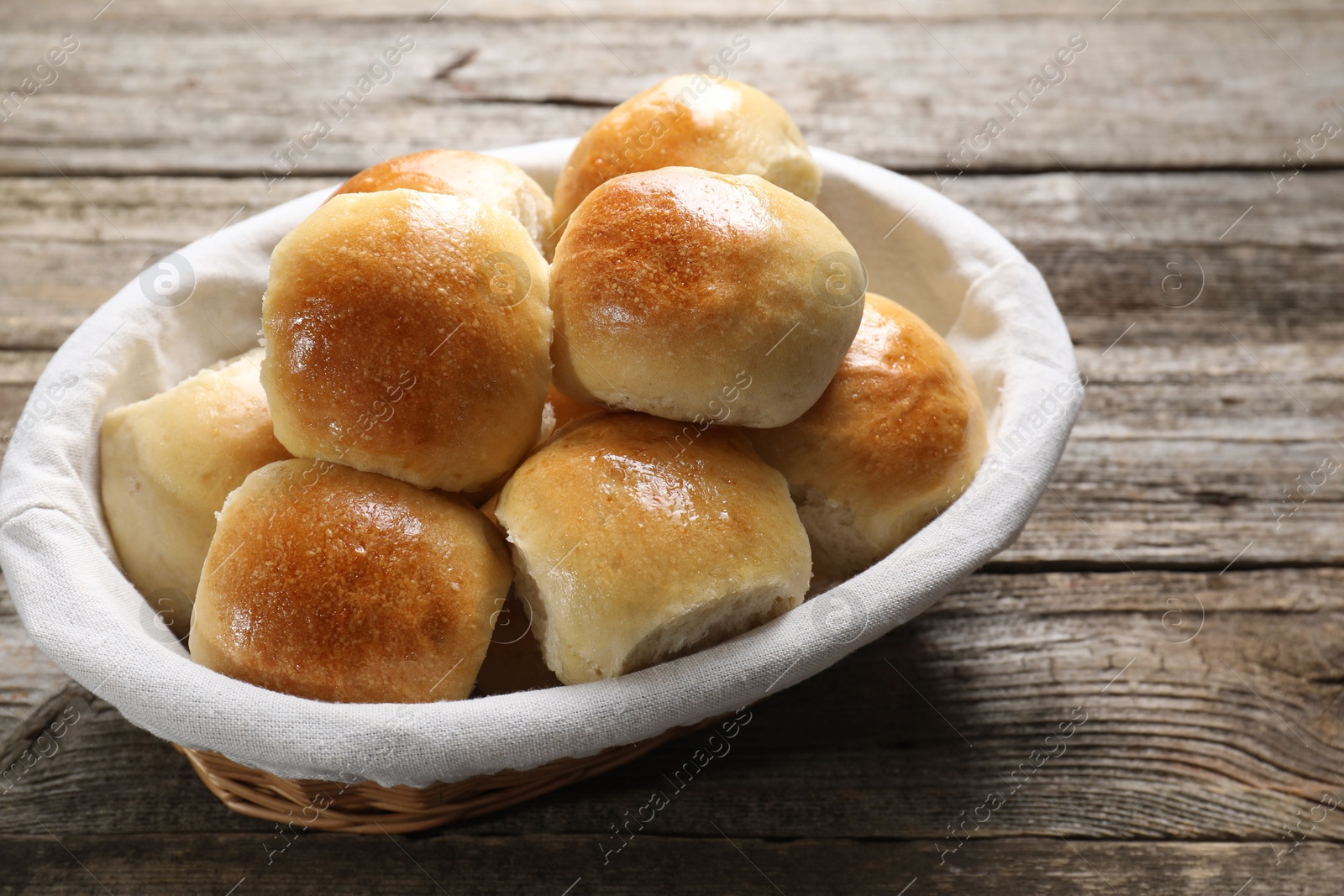 Photo of Delicious dough balls in basket on wooden table