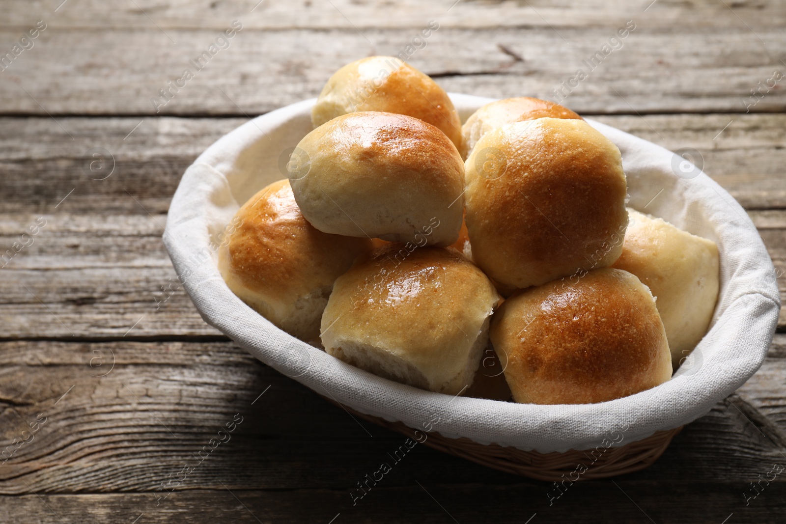 Photo of Delicious dough balls in basket on wooden table