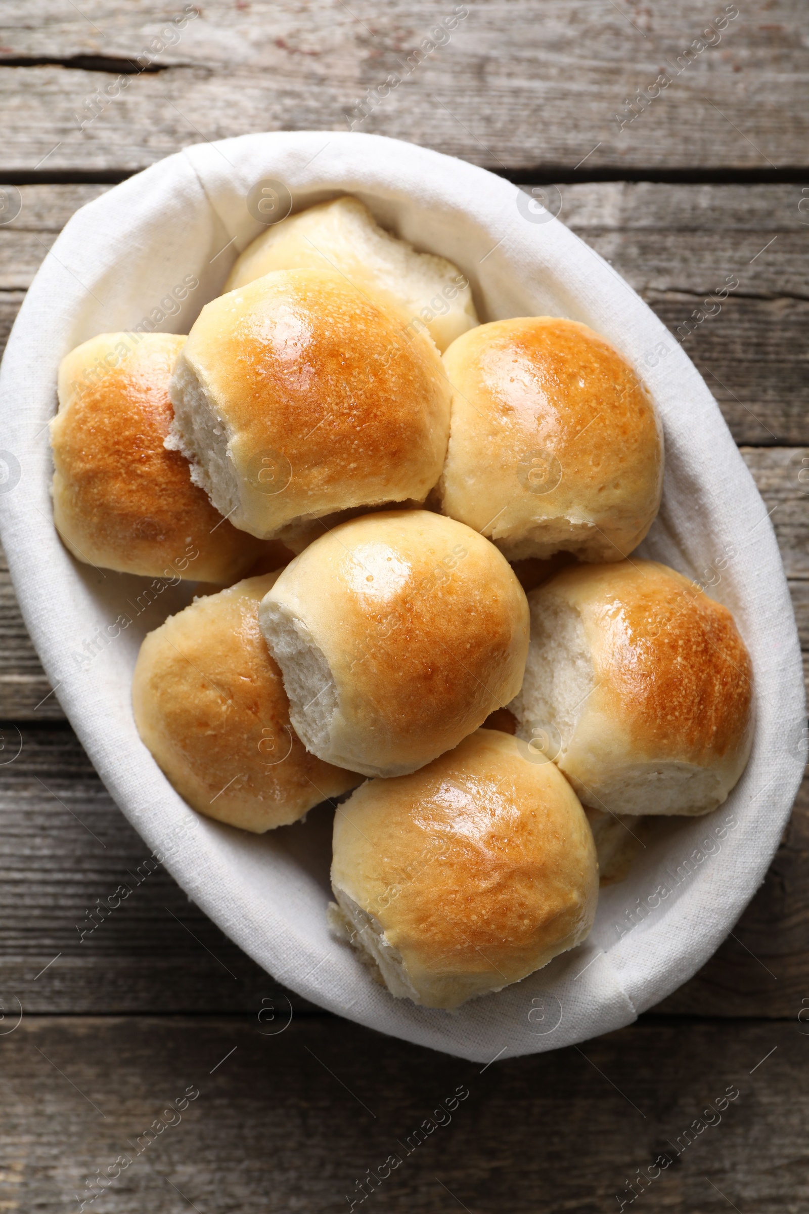 Photo of Delicious dough balls in basket on wooden table, top view