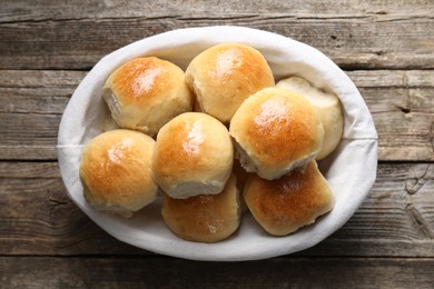 Photo of Delicious dough balls in basket on wooden table, top view