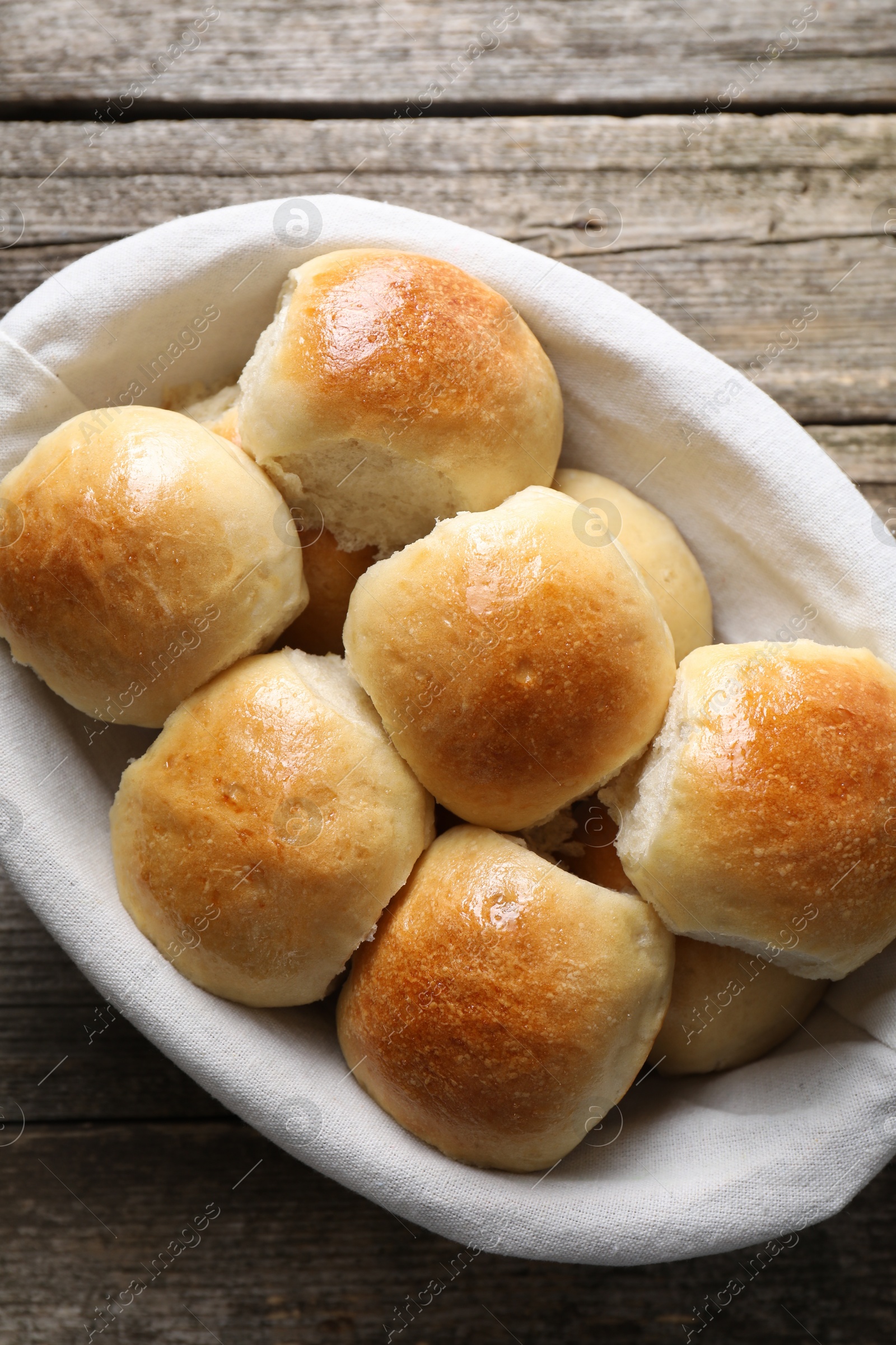 Photo of Delicious dough balls in basket on wooden table, top view