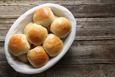 Photo of Delicious dough balls in basket on wooden table, top view. Space for text