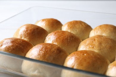 Photo of Delicious dough balls in baking dish on table, closeup