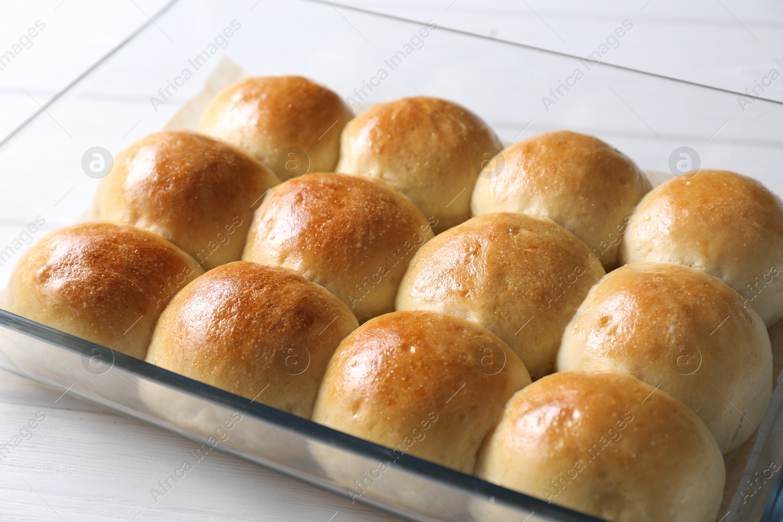 Photo of Delicious dough balls in baking dish on white wooden table