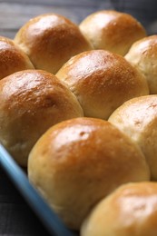 Delicious dough balls in baking dish on table, closeup