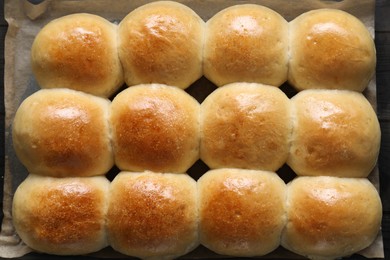 Delicious dough balls on parchment paper, top view