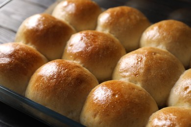 Photo of Delicious dough balls in baking dish on table, closeup