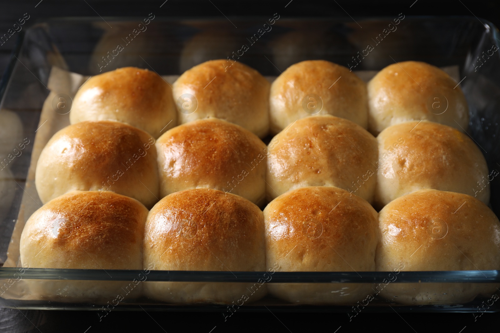 Photo of Delicious dough balls in baking dish on table, closeup