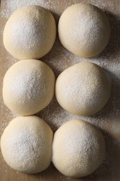 Photo of Raw dough balls on wooden table, top view