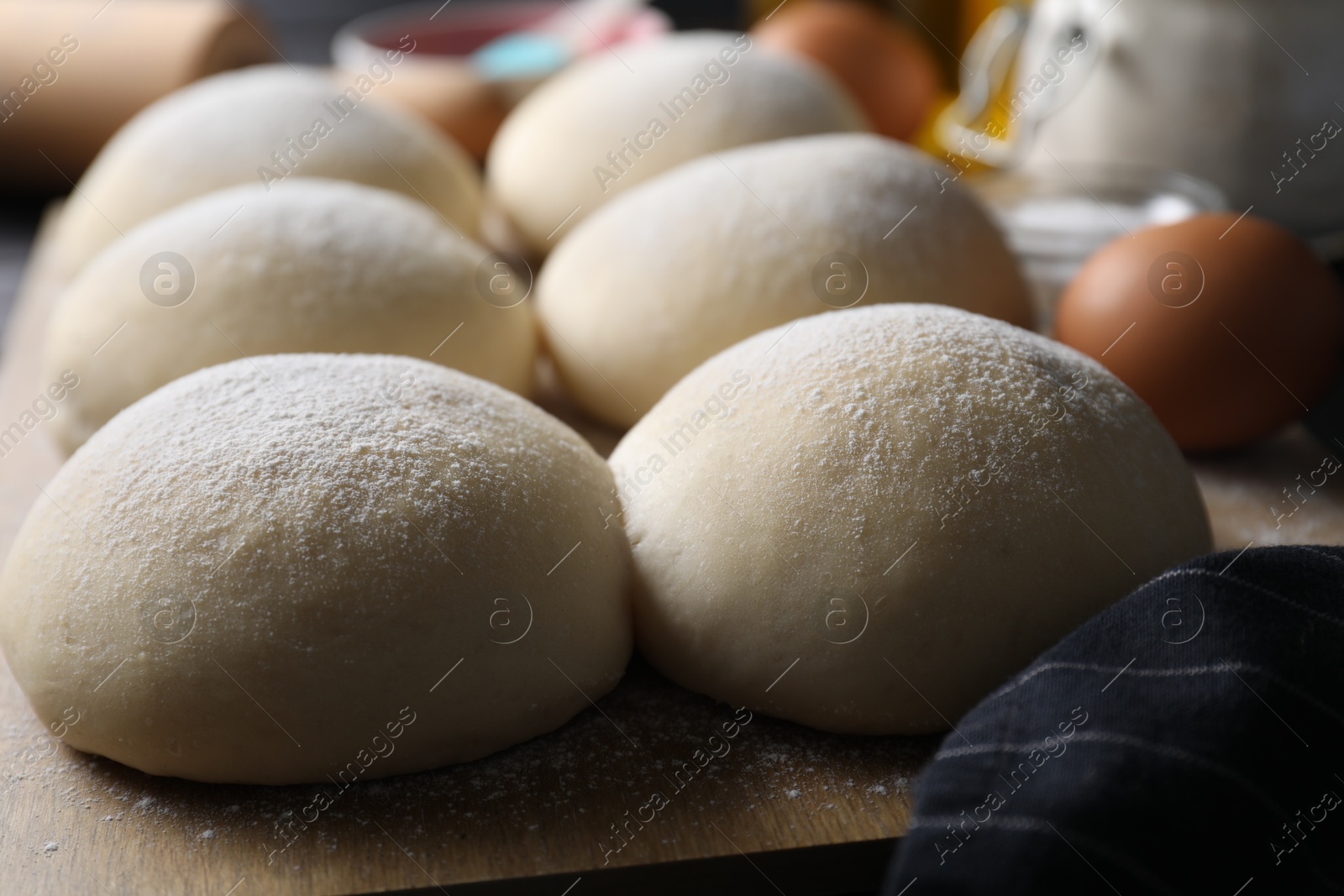 Photo of Raw dough balls with flour on table