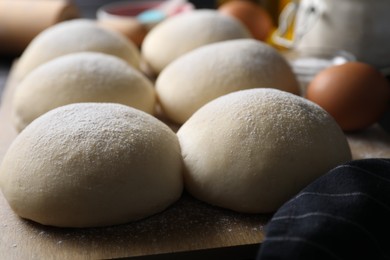 Raw dough balls with flour on table