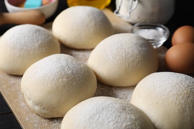 Photo of Raw dough balls with flour, eggs and salt on table