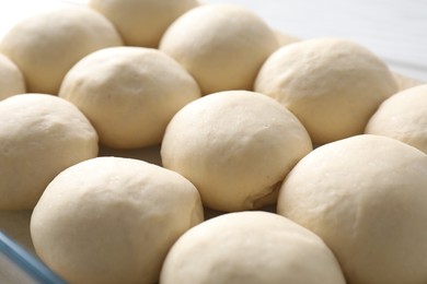 Photo of Raw dough balls in baking dish, closeup