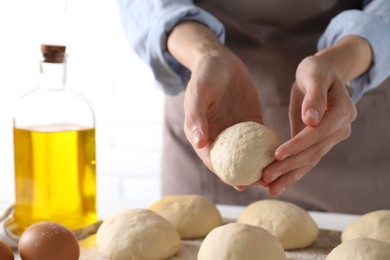 Photo of Woman making dough ball at table, closeup