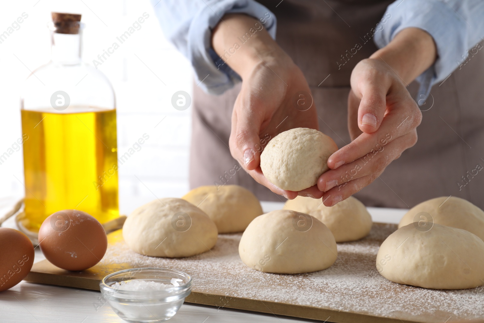 Photo of Woman making dough ball at table, closeup