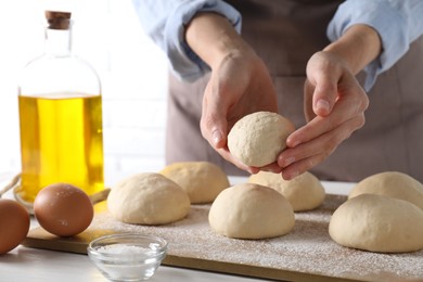 Woman making dough ball at table, closeup