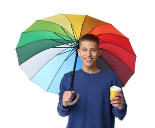 Young man with rainbow umbrella and cup of drink on white background