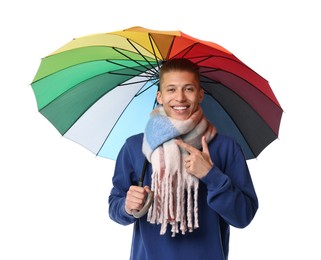 Young man with rainbow umbrella pointing on white background