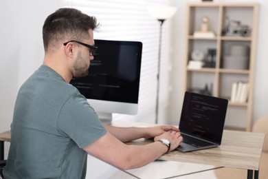 Young programmer working at desk in office