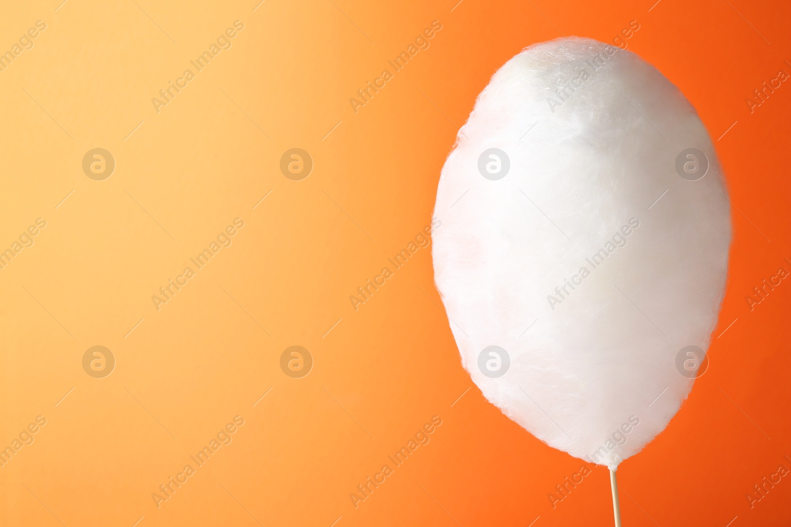 Photo of One sweet cotton candy on orange background. Space for text