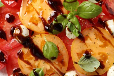 Photo of Tasty salad with balsamic vinegar and mozzarella on plate, top view