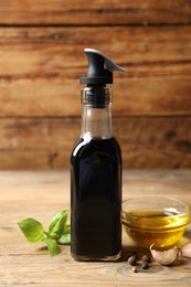 Bottle of balsamic vinegar, oil and other products on wooden table