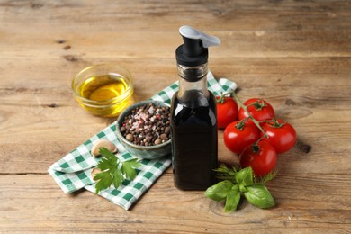 Photo of Bottle of balsamic vinegar, oil and other products on wooden table