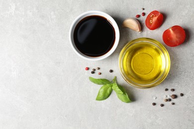 Photo of Balsamic vinegar, oil and other products on light grey table, flat lay. Space for text