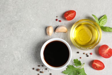 Balsamic vinegar, oil and other products on light grey table, flat lay. Space for text