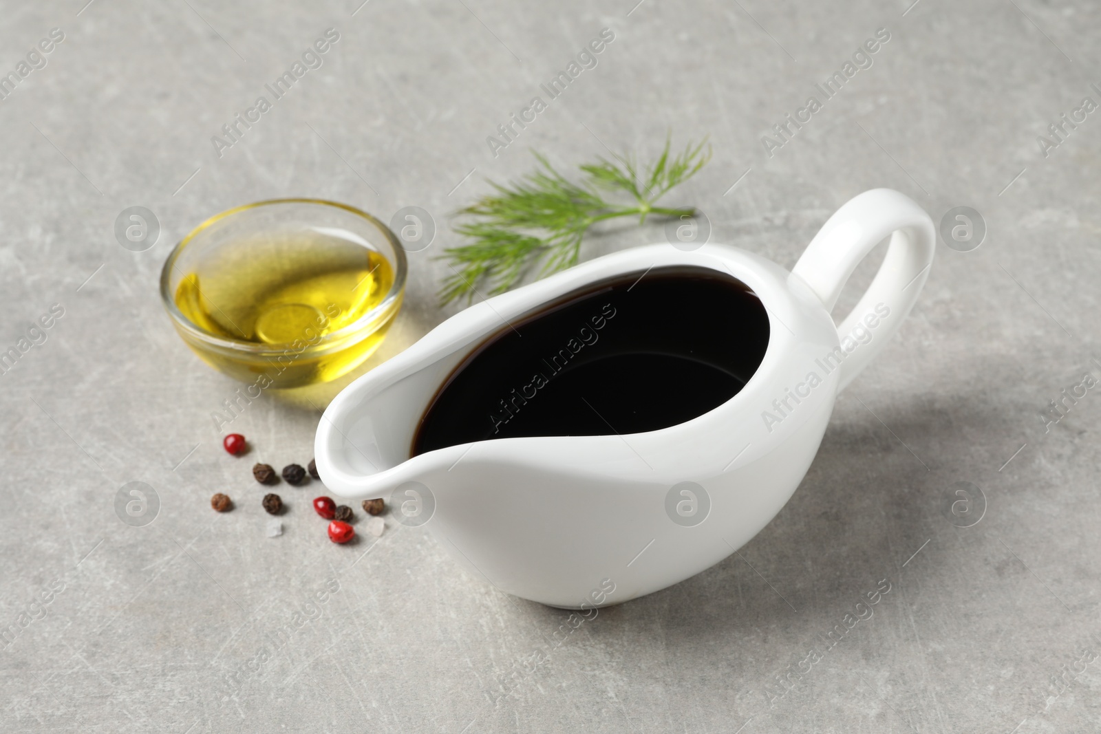 Photo of Balsamic vinegar, oil, peppercorns and dill on light grey table