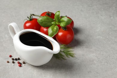 Photo of Balsamic vinegar and other products on light grey table, space for text