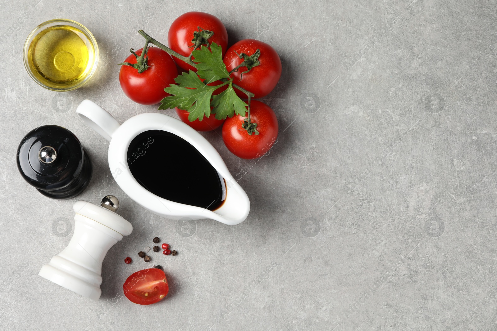 Photo of Balsamic vinegar, oil and other products on light grey table, flat lay. Space for text