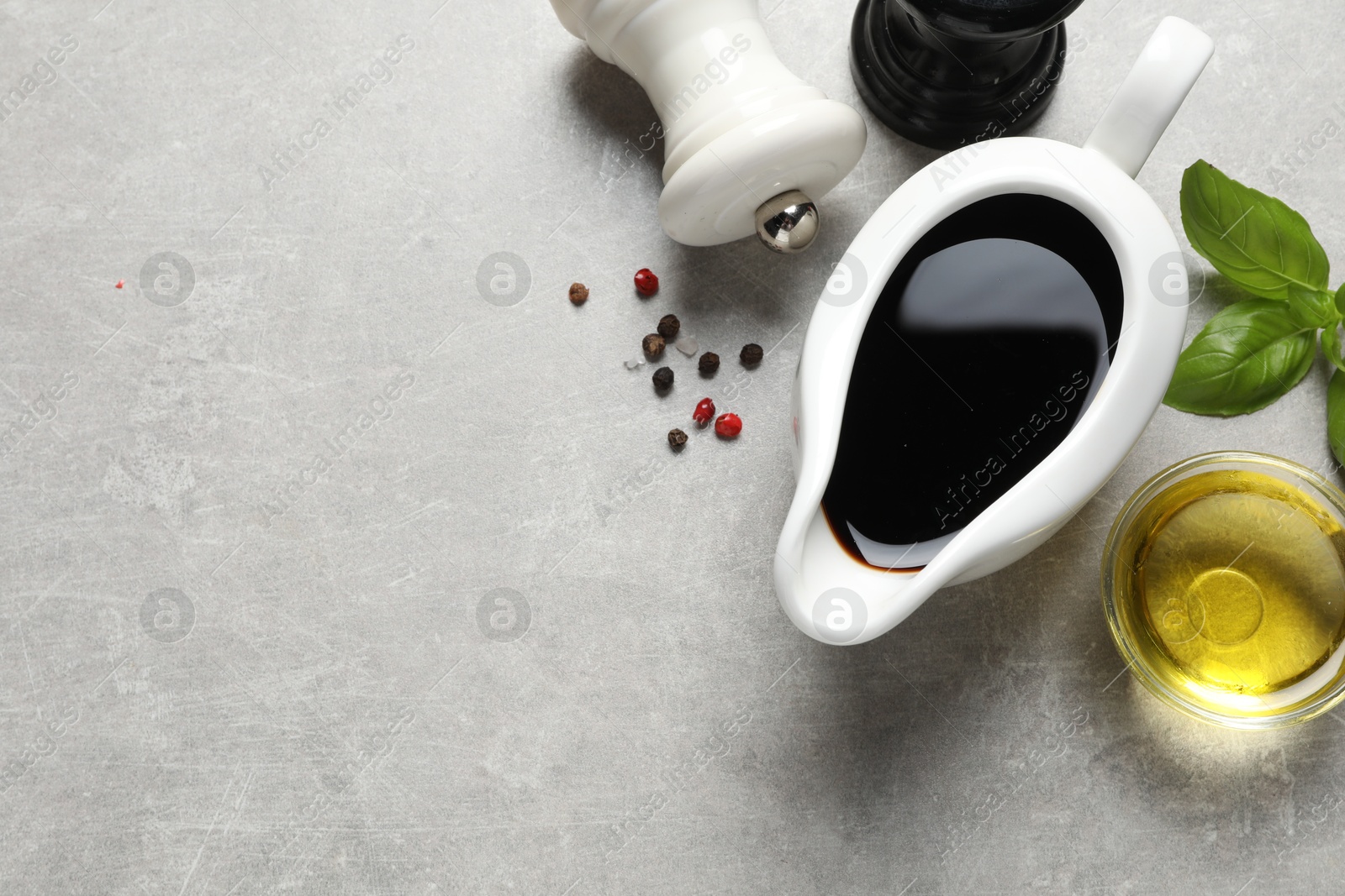 Photo of Balsamic vinegar, oil and other products on light grey table, flat lay. Space for text