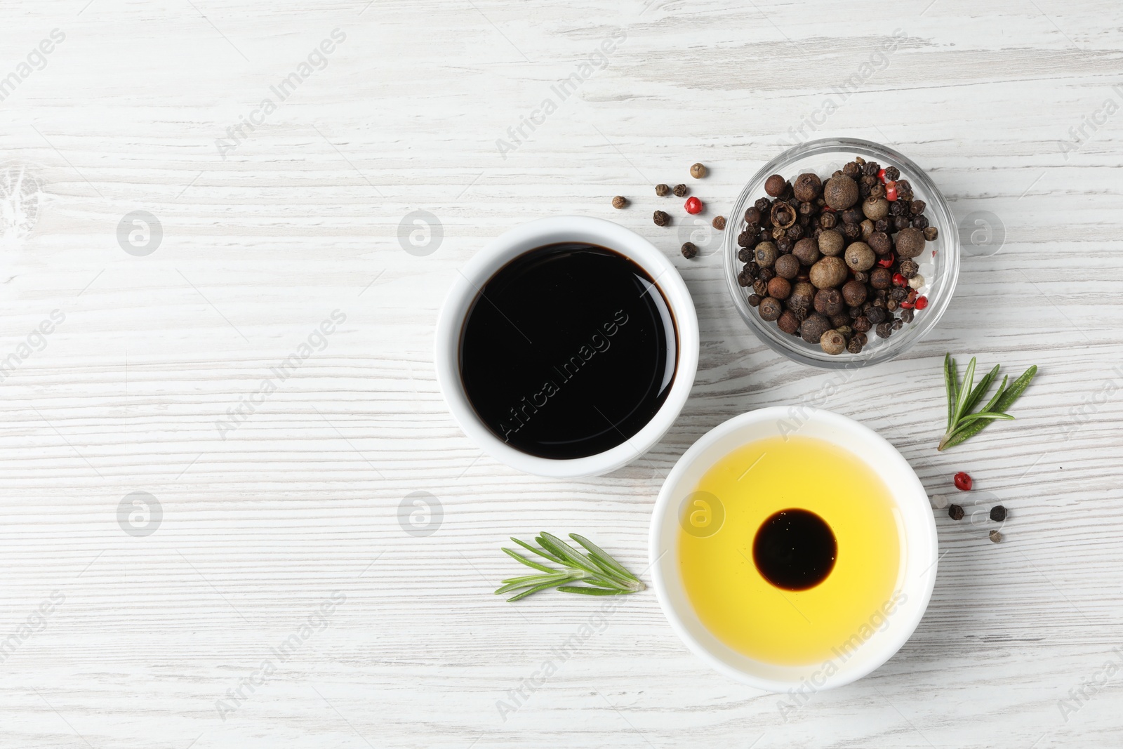 Photo of Balsamic vinegar, oil and other products on white wooden table, flat lay. Space for text