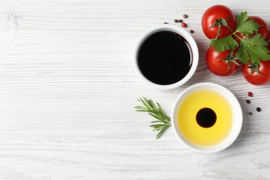 Photo of Balsamic vinegar, oil and other products on white wooden table, flat lay. Space for text