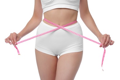 Photo of Diet and weight loss concept. Woman with measuring tape showing her slim body against white background, closeup