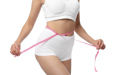 Photo of Diet and weight loss concept. Woman with measuring tape showing her slim body against white background, closeup