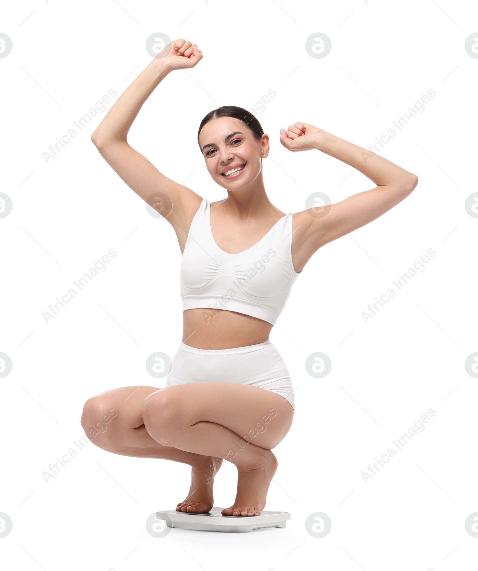 Photo of Diet and weight loss concept. Happy young woman on floor scale against white background