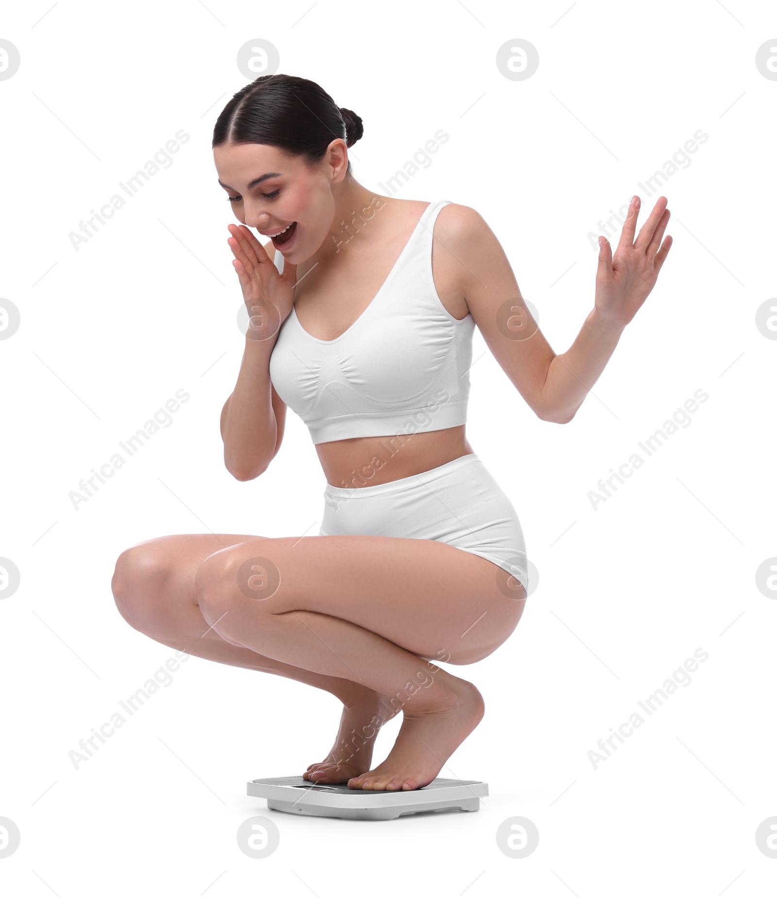 Photo of Diet and weight loss concept. Happy young woman on floor scale against white background